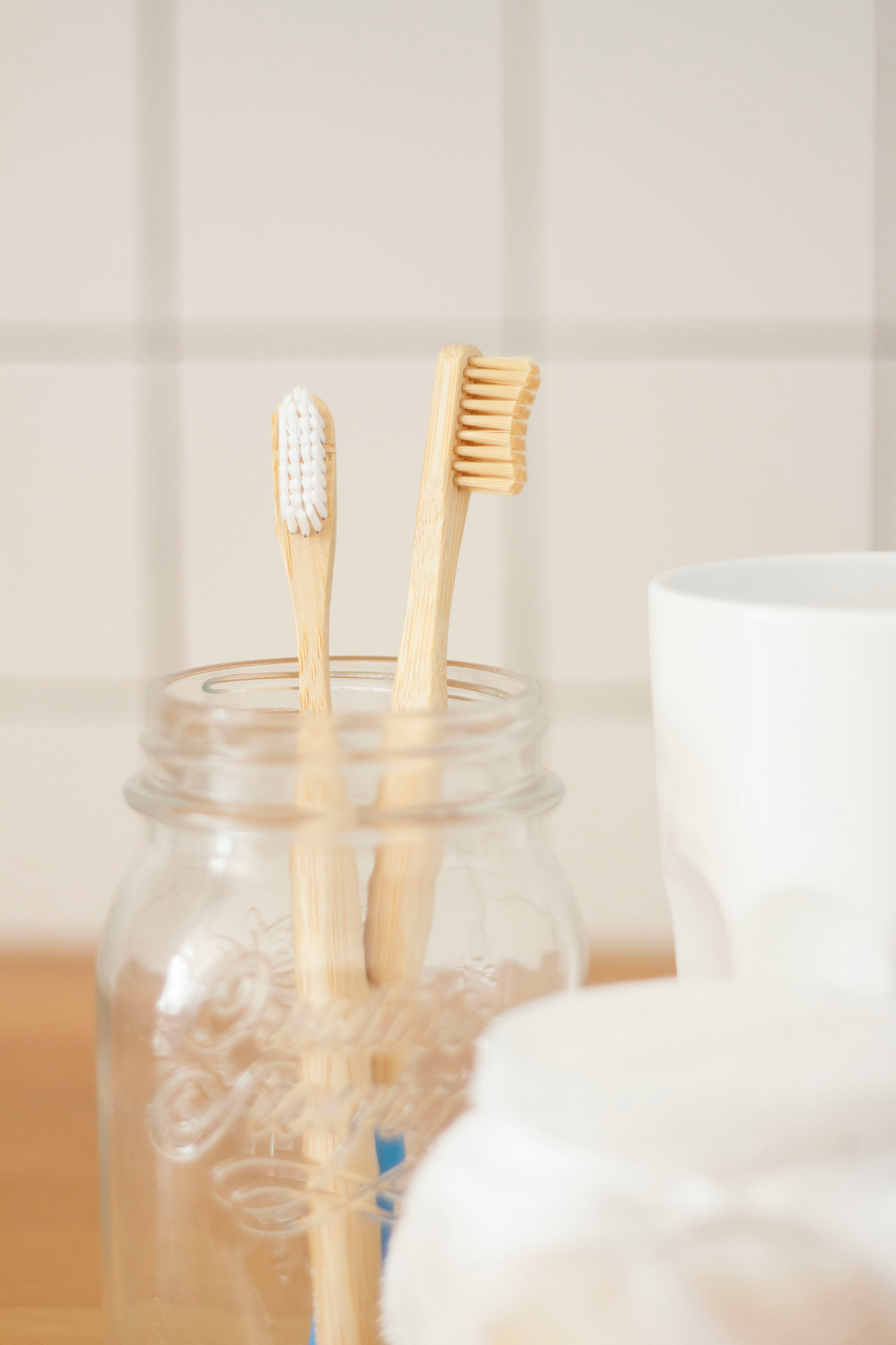 Two toothbrushes in a glass, ready for nighttime brushing