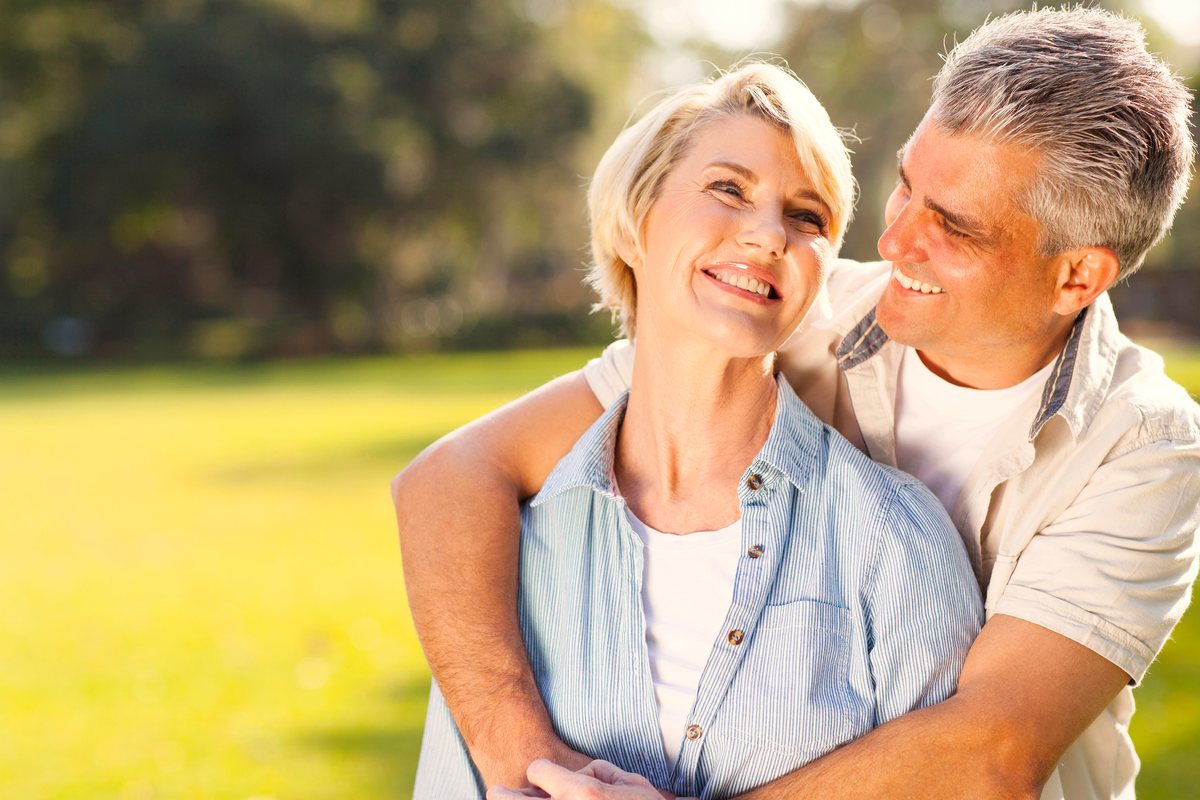 A couple smiling with relief outdoors on a sunny day